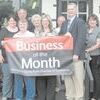 Business of the Month banner is displayed by Kathy Chandler, owner of the Sweet Shoppe Rock, Mayor Angela Raiborn and Bob Goldsberry, chamber of commerce executive director. The business was named Rusk Business of the Month for October. Chamber members and Rusk leaders attended the presentation Thursday morning.