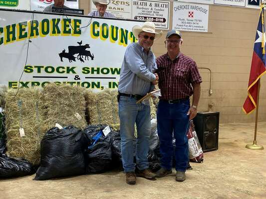 A sample consisting of 14.16 percent crude protein submitted by Wade McKnight was named Reserve Grand Champion of this year’s Cherokee County Hay Show. Shown are Scruggs and Bill McKnight, who stood in for his son, Wade, who was unable to attend the sale, said organizers. 

Photo courtesy Cherokee County AgriLife Extension