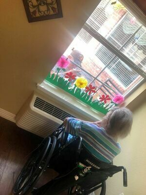 An Arbors resident attends a window visit from a loved one in Rusk recently.